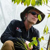 A person sits inside a controlled research environment used for a spotted lanternfly research experiment.