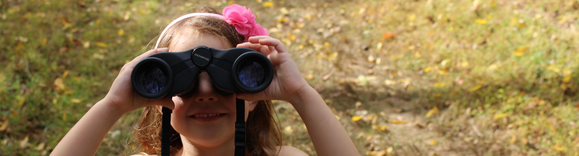Girl looking through binoculars at the camera