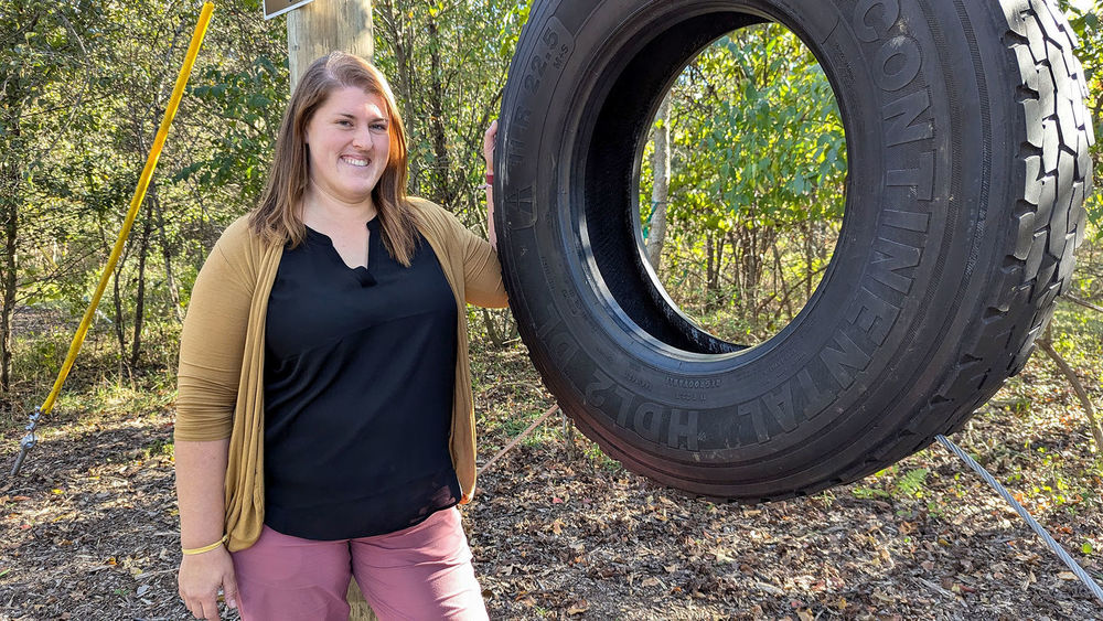 Holly Lynn in front of a low ropes challeneger course element