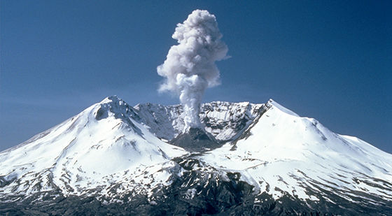 The top of Mount Saint Helens. A crater in the top of a mountain, with a small volcano cone in the middle of it