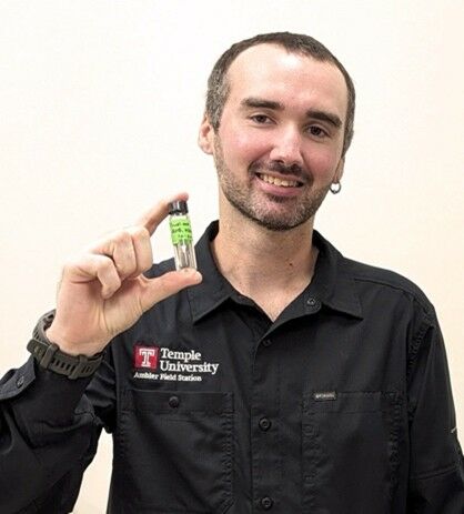 MSc Chris LeClair holding a sample vial