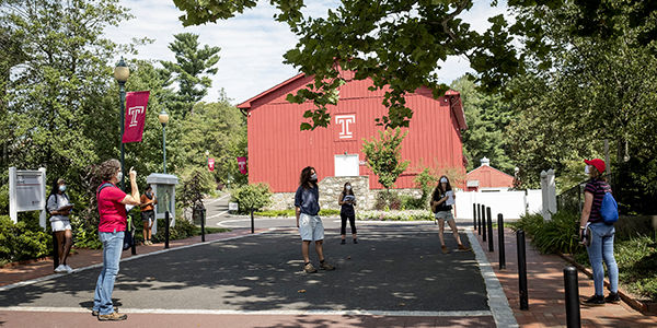 students walking in front of the red barn gym