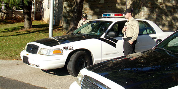 Student cadets next to a law enforcement training car
